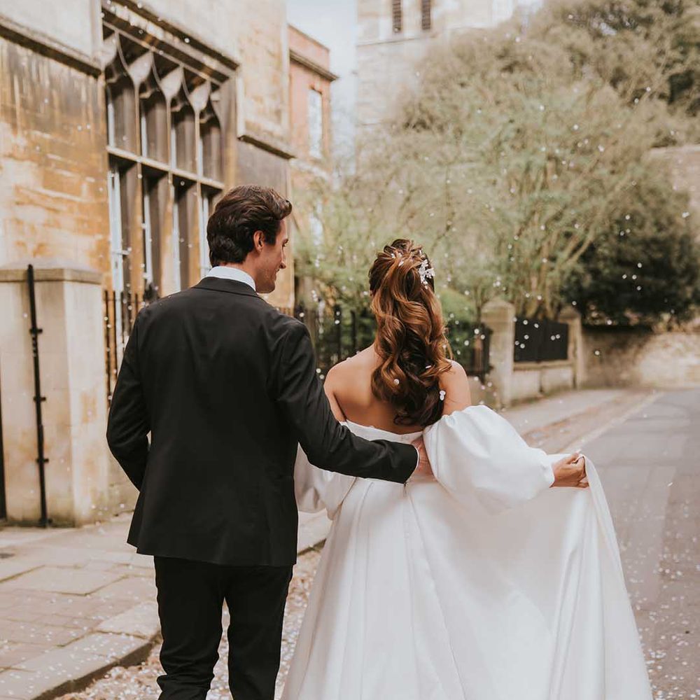 Confetti moment with bride in a strapless wedding with high wavy ponytail 