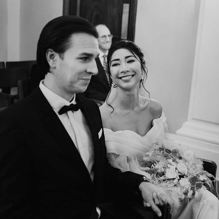 Off the shoulder heart shape cut wedding dress bride smiles with groom in bow tie 