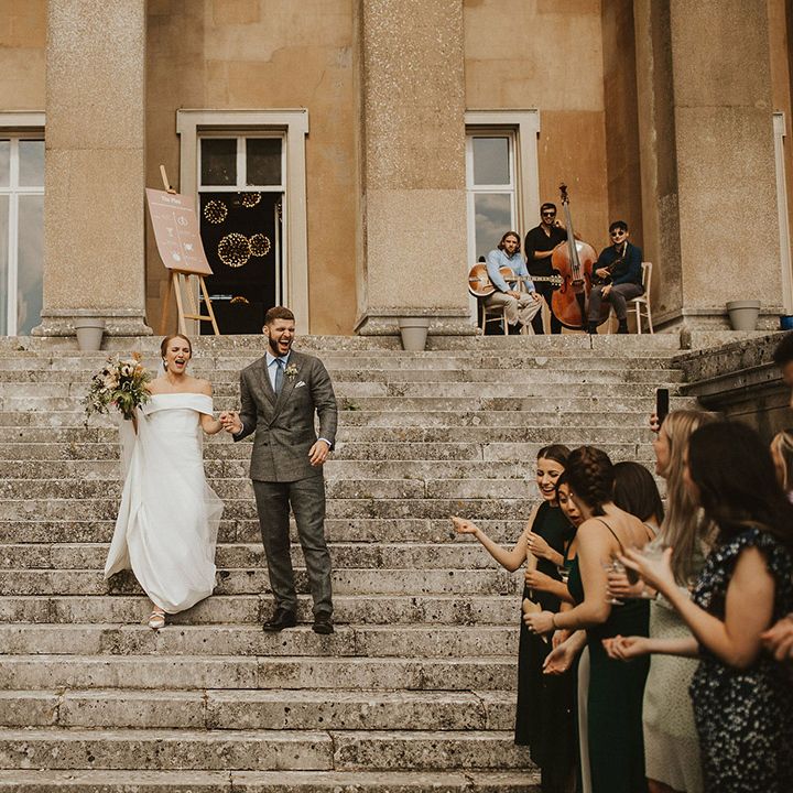 Bride & groom walk down grand steps after wedding ceremony at The Grange Hampshire