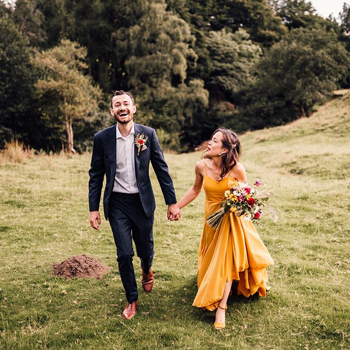 Bride & groom walk across hills 