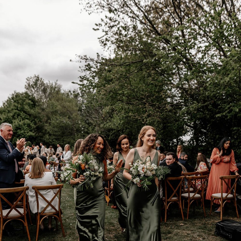 Bridal party in sage green bridesmaid dresses at outdoor back garden wedding 