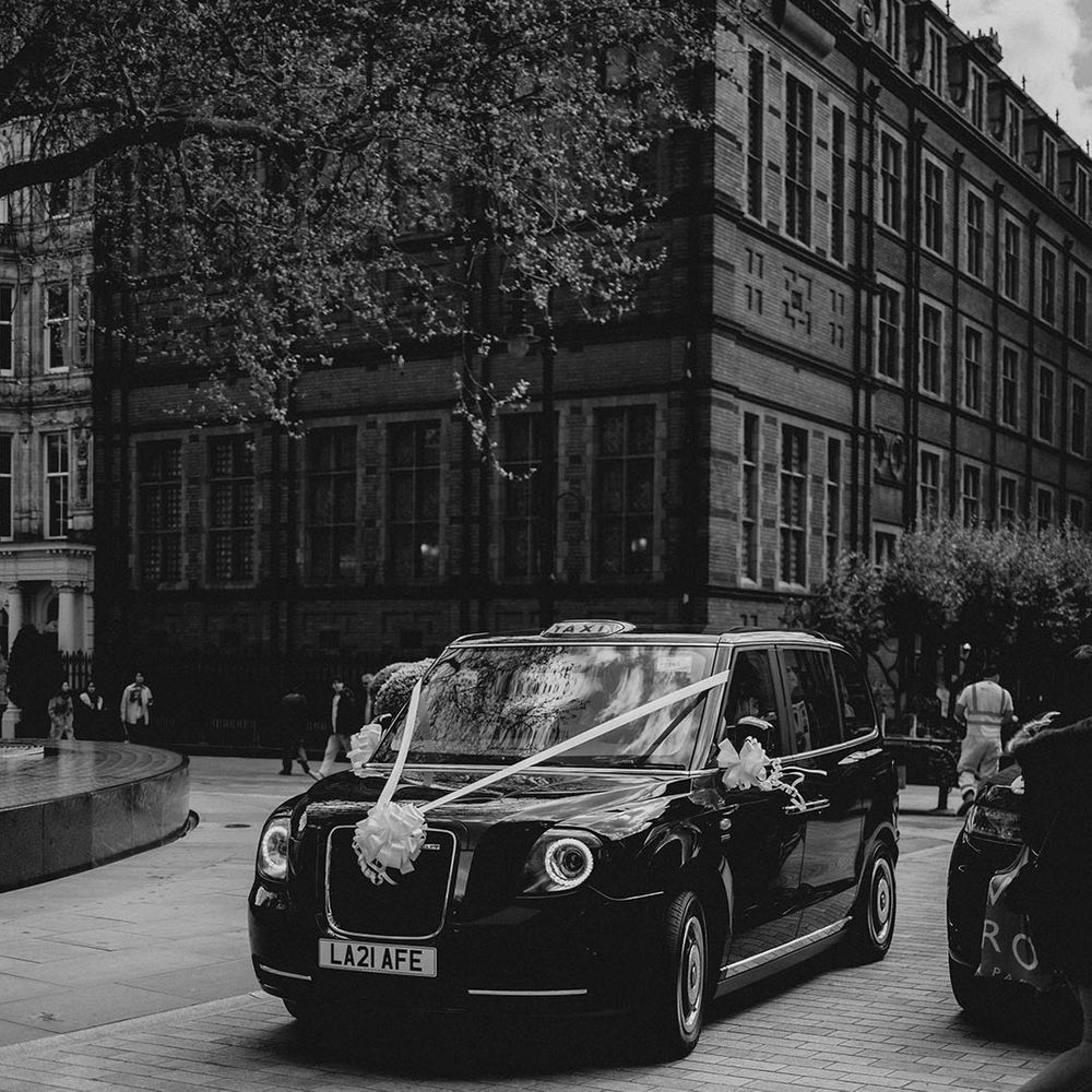 London black cab wedding car transport decorated with white ribbon 