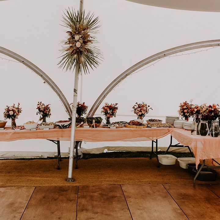 Boho styled wedding reception in marquee with buffet food and dried floral arrangements 