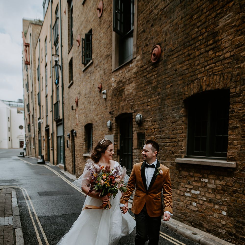 Bride and Groom hold hands and walk through the streets at London Wedding