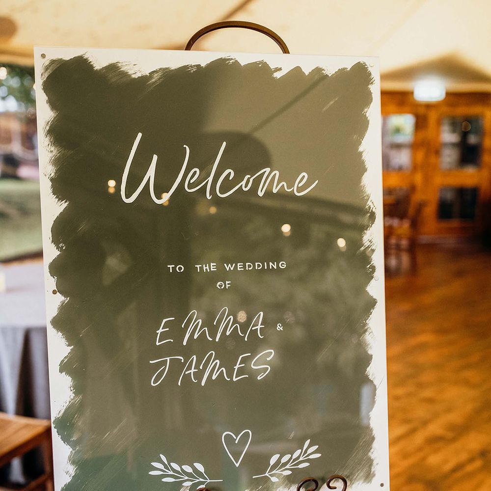 Modern styled wedding sign on metal easel for barn wedding ceremony 