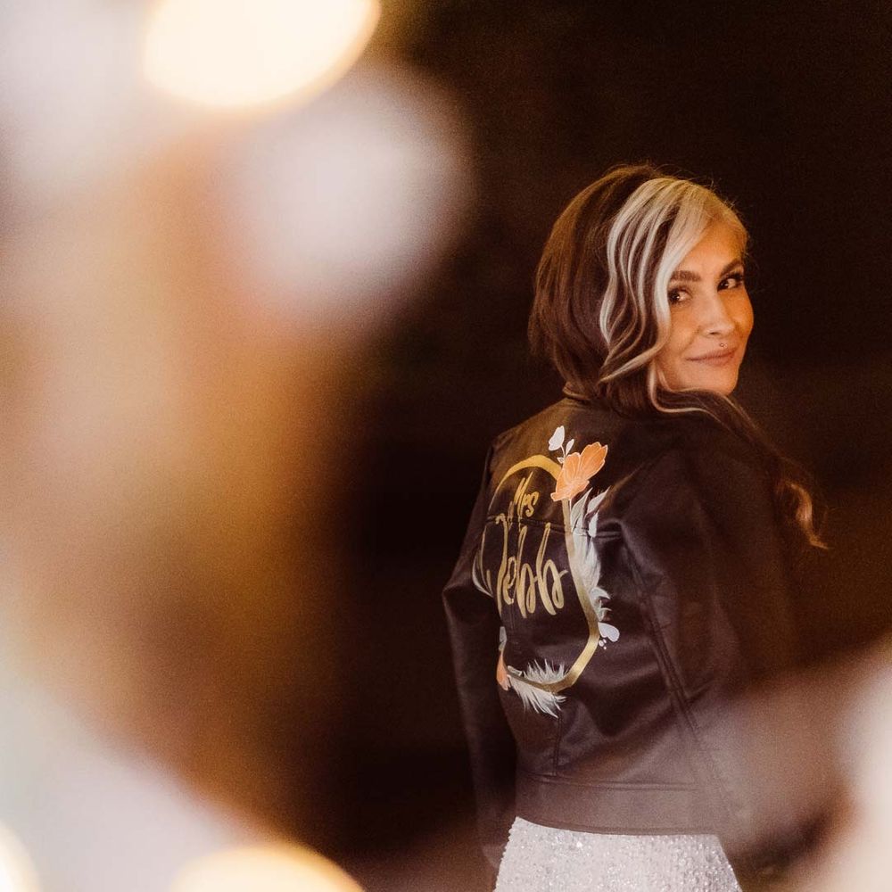 Bride in personalised leather jacket bridal cover up and sparkly wedding dress 