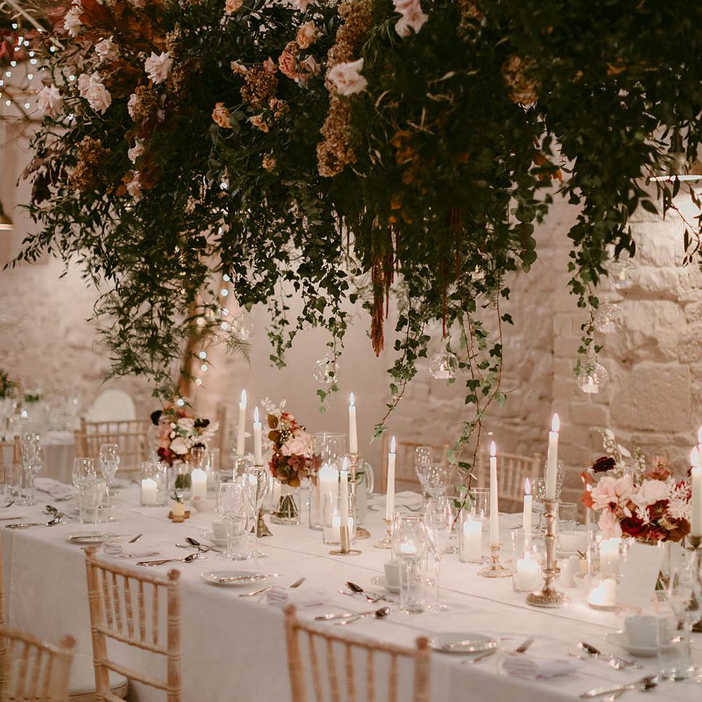 Pink rose wedding flower hanging installation over wedding table with white tablecloth 