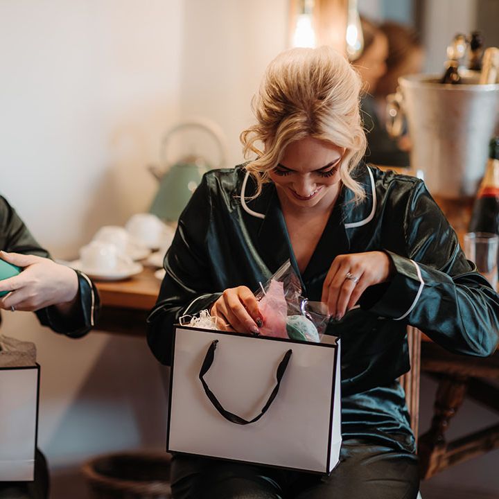Bridesmaids in their pyjamas opening bridesmaid gifts on the morning of the wedding 