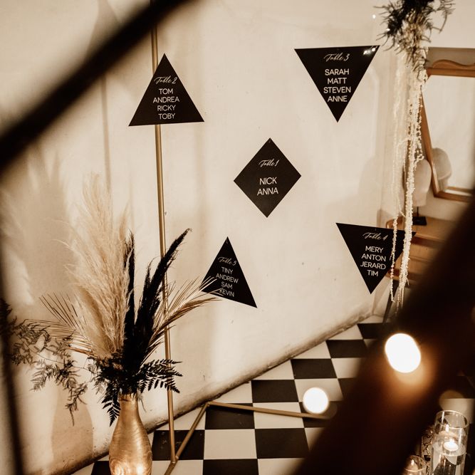 Black suspended table plan next to gold vases