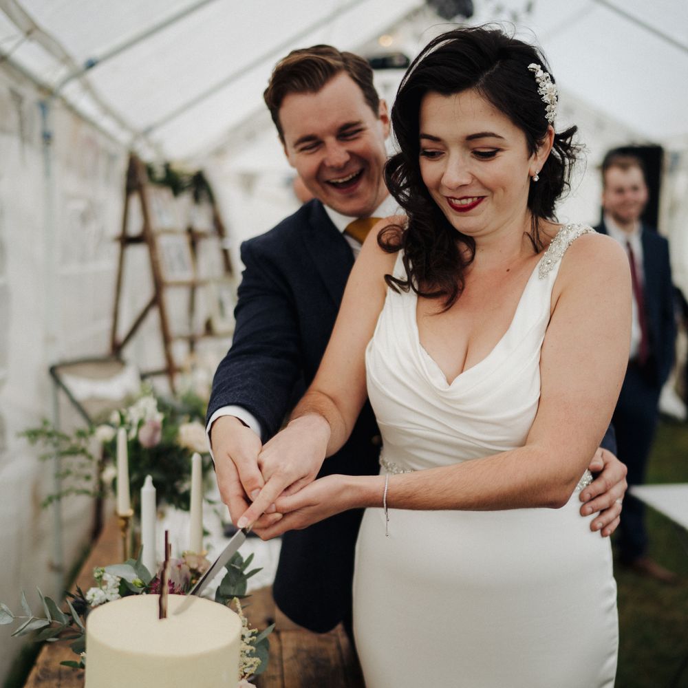 Bride & groom cut their cake at wedding reception 
