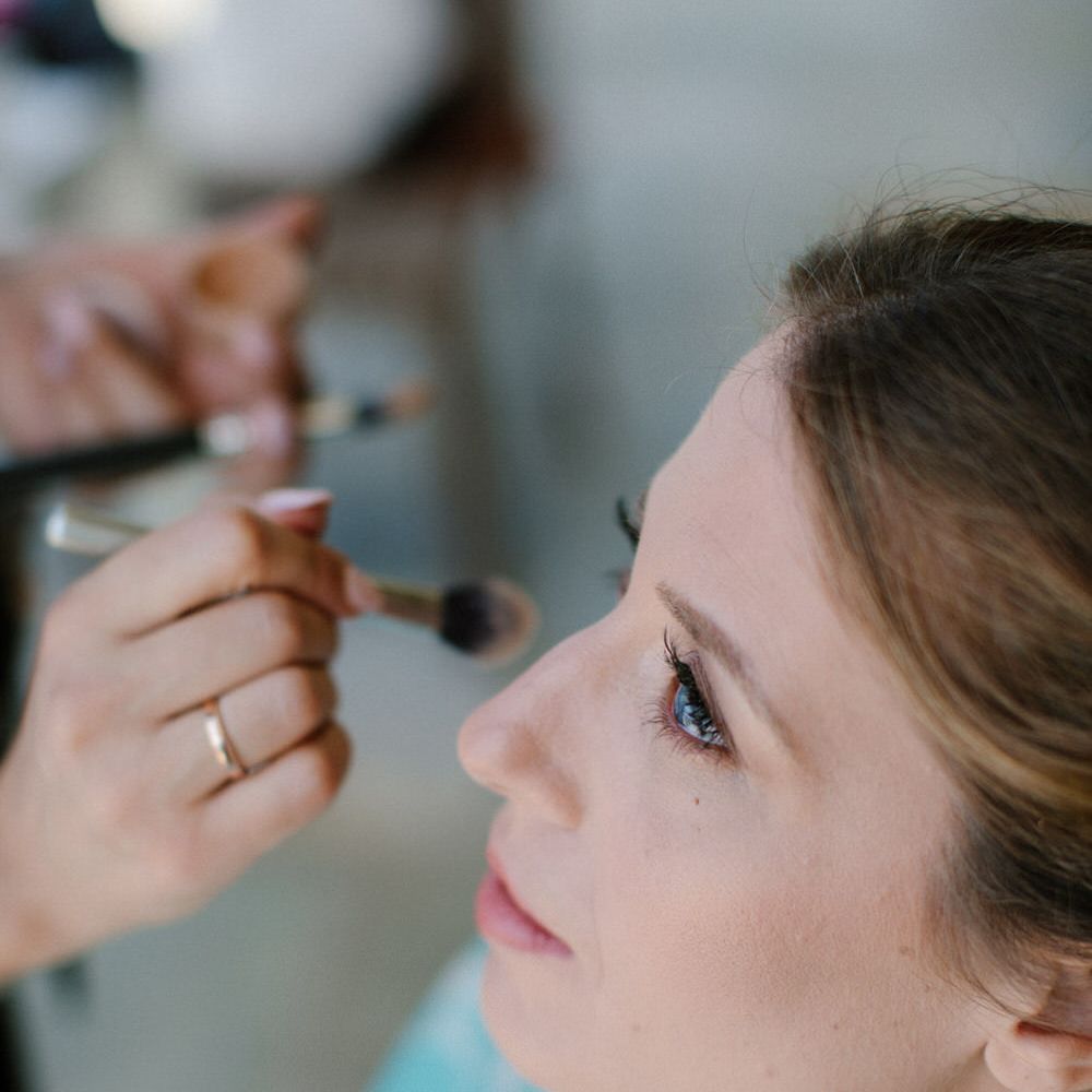 The bride having her make up done for her destination wedding in Greece
