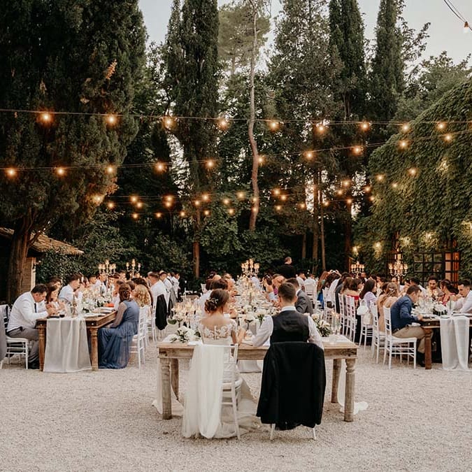 Bride & groom sit at the head of wedding reception for outdoor wedding in Italy  | Royal Studio