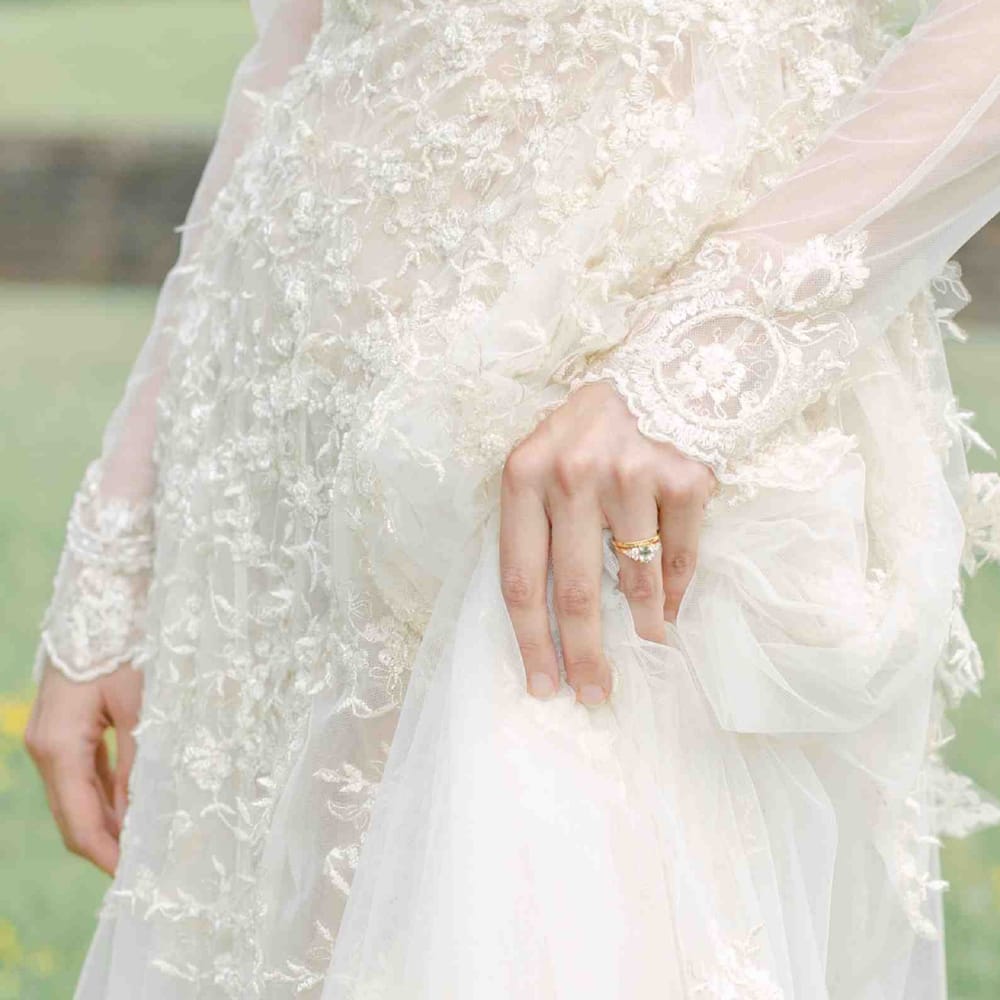 Bride in a lace wedding dress with a pale green sapphire engagement ring for pastel wedding inspiration at Botley's Mansion 