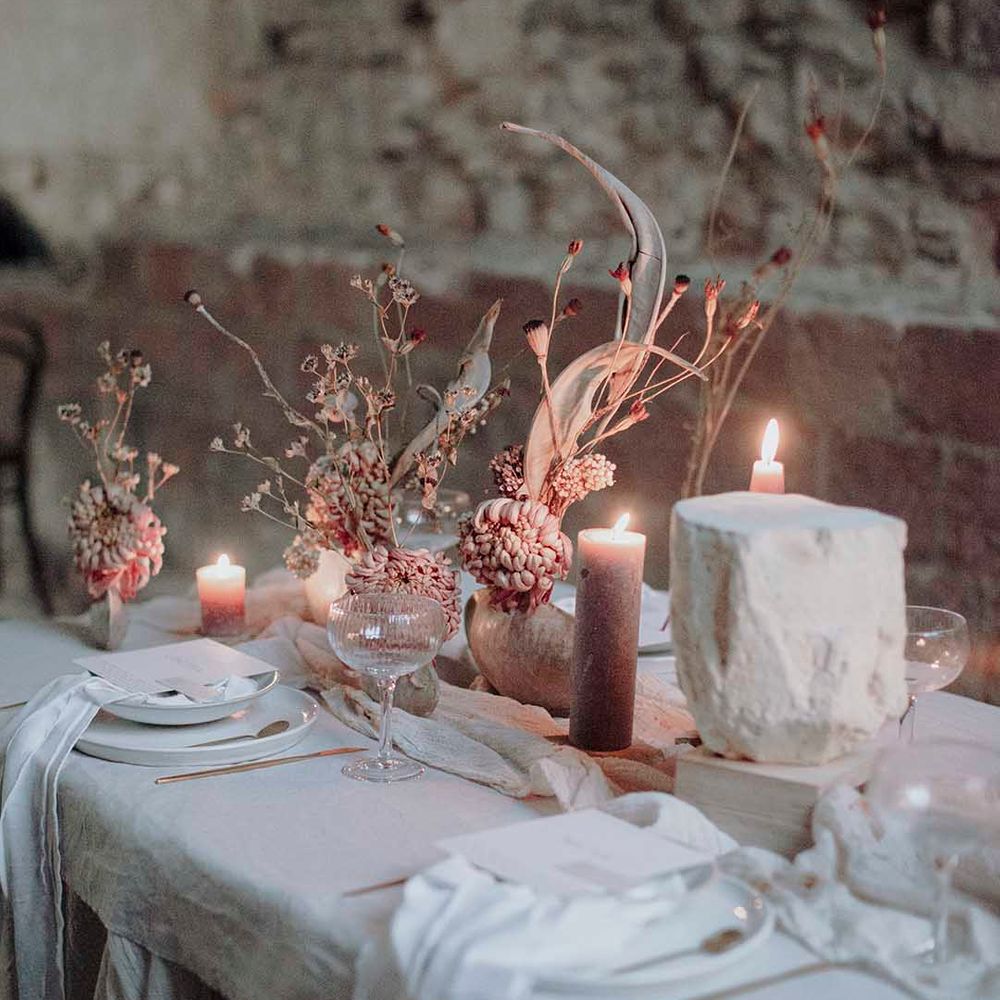 Gothic wedding table decor with natural linens, pillar candles and minimalist wedding flowers