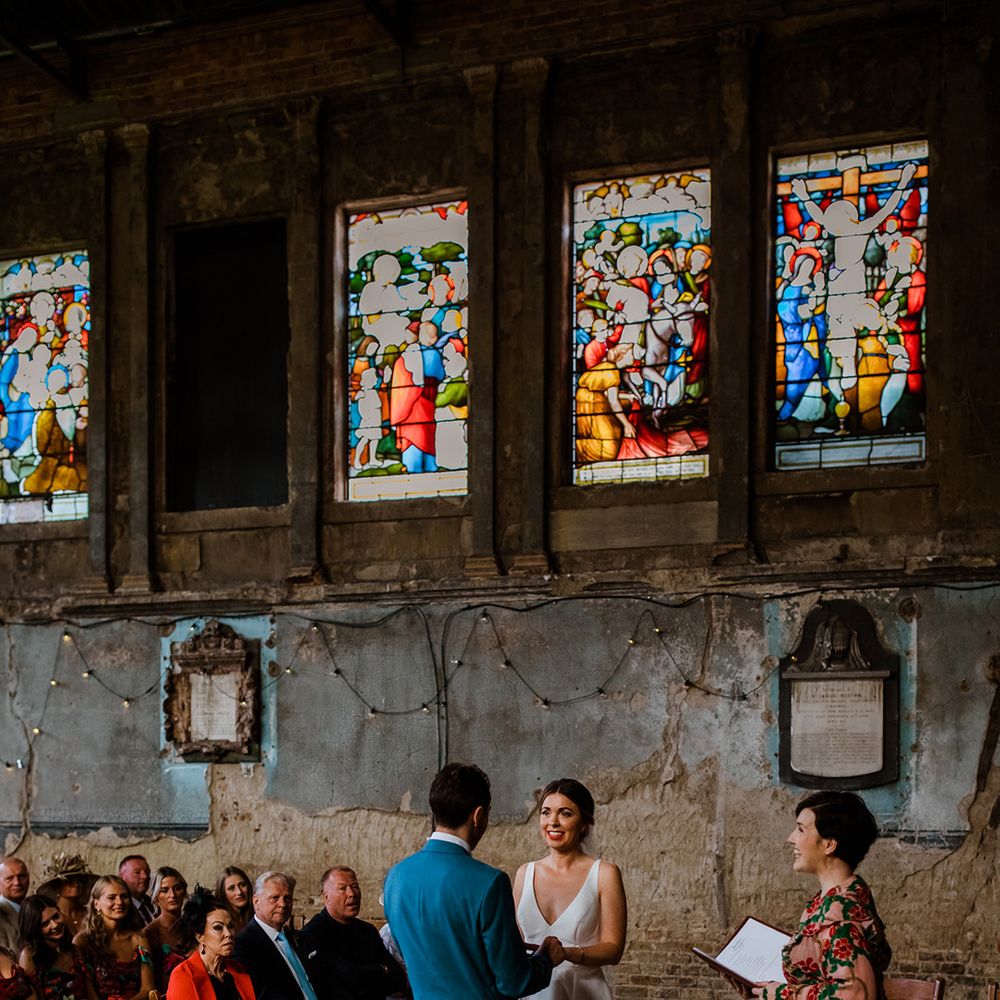Humanist wedding ceremony for bride and groom at industrial chapel wedding with stained glass windows