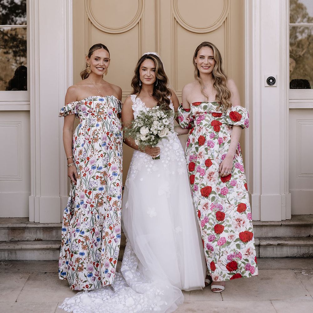 Bride in floral applique wedding dress with white bouquet with bridesmaids in flower print dresses 