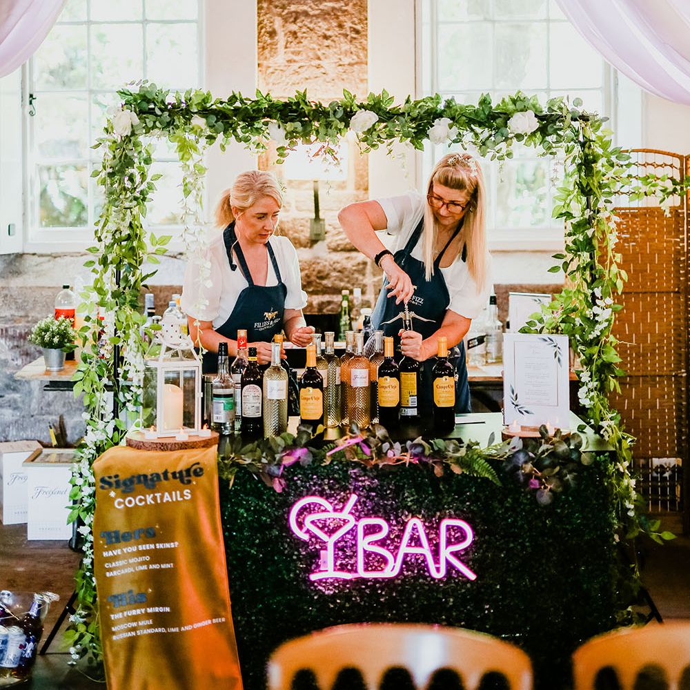 Wedding bar complete with green foliage, pink neon sign and fabric banner