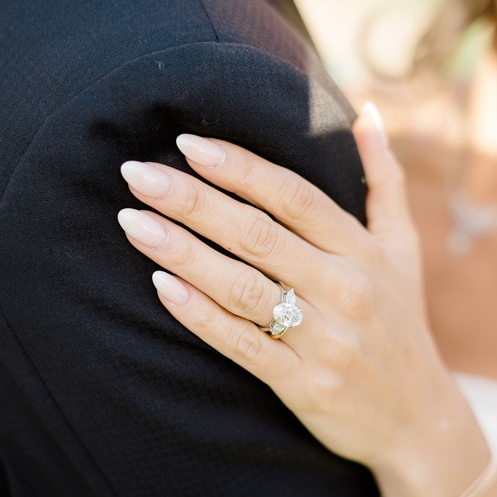 Bride wears neutral nail varnish and diamond engagement ring 
