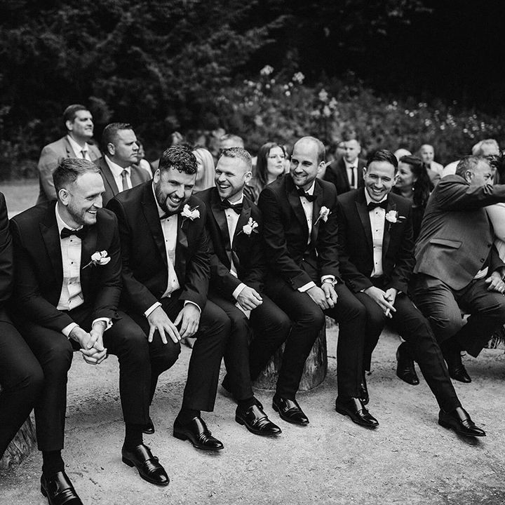 The groomsmen in black tie all sit together on the front row for the wedding ceremony at The Orangery 