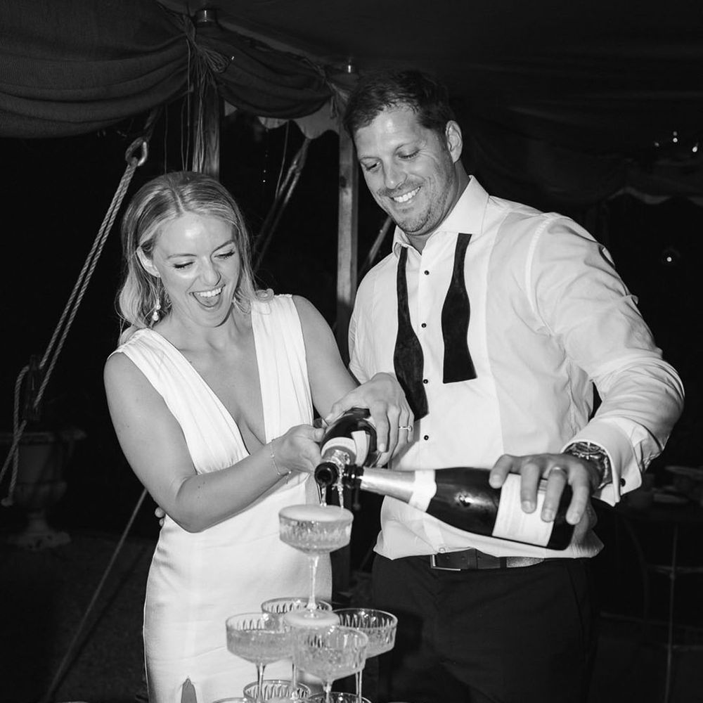 Bride and groom pour a champagne tower at their wedding 