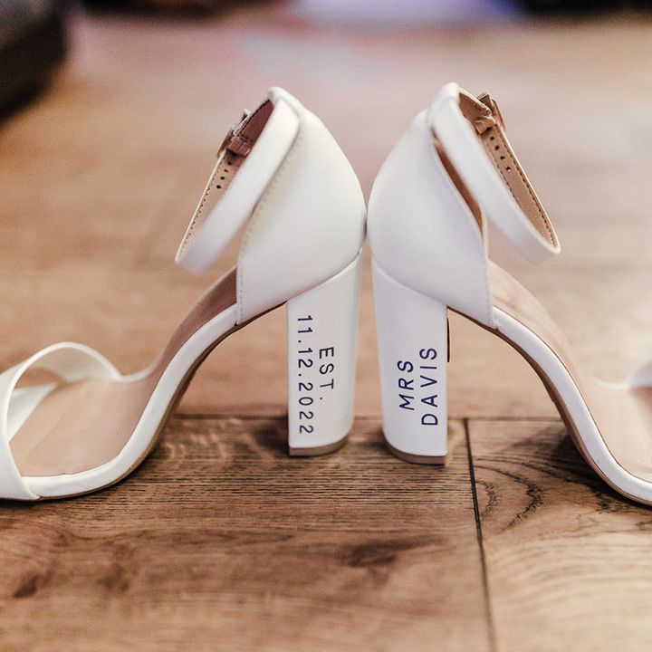 The bride's white block heel wedding shoes with personalisation on the heels 