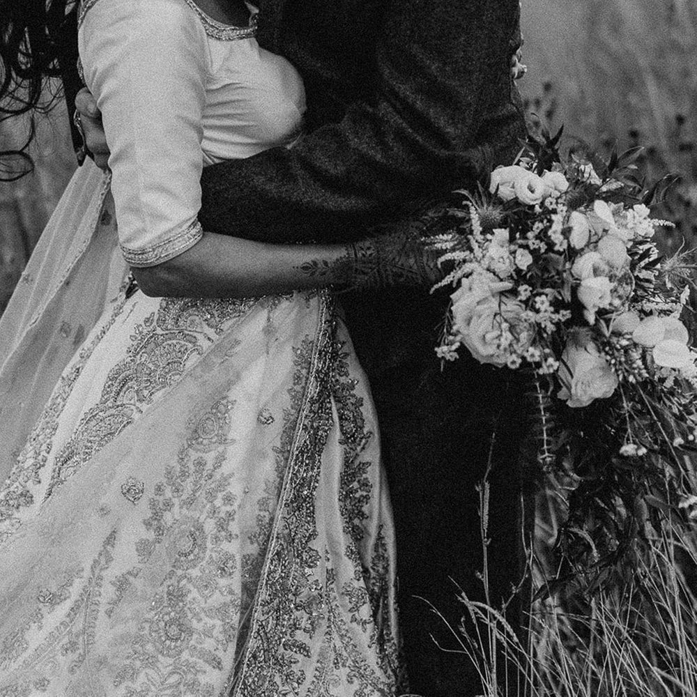 Black and white wedding photo of the bride and groom sharing an embrace