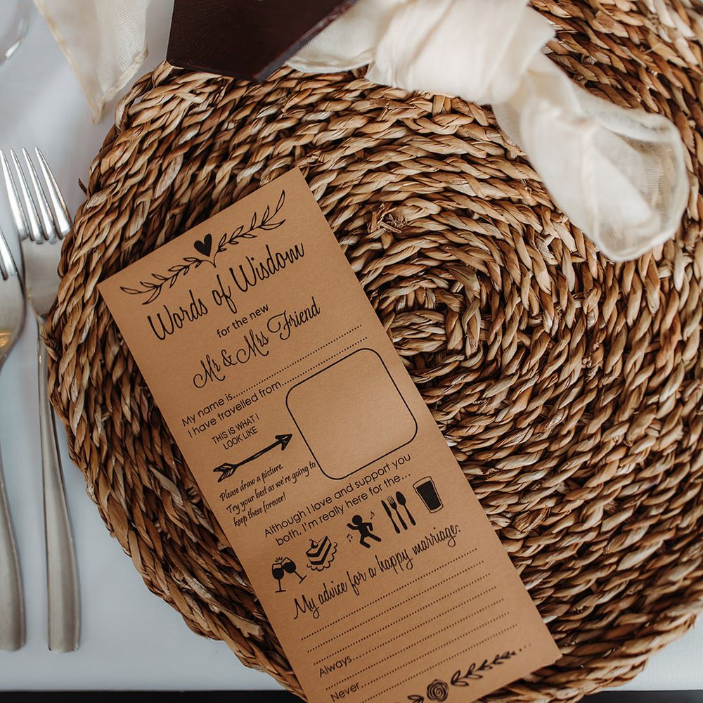 Wicker place mat with a sheer napkin, burgundy wedding place name and wedding game card