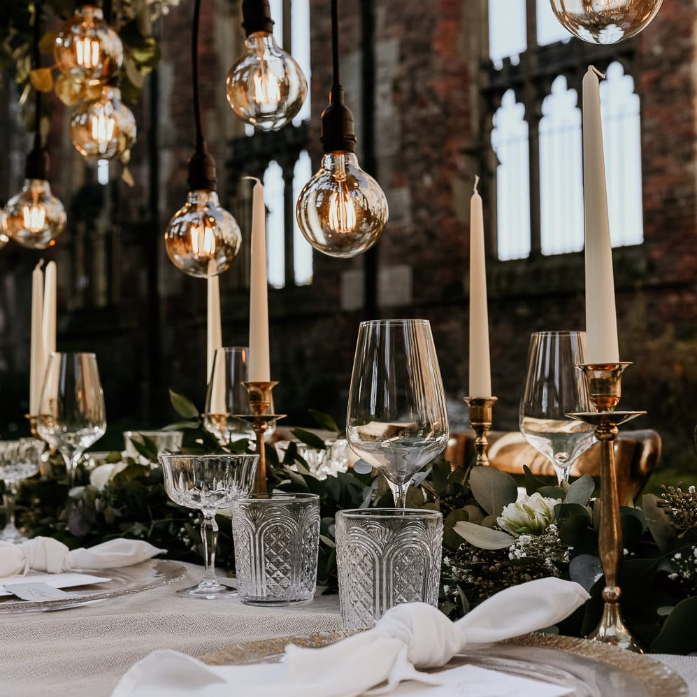 Elegant wedding table glassware, gold candlesticks and foliage table runner 