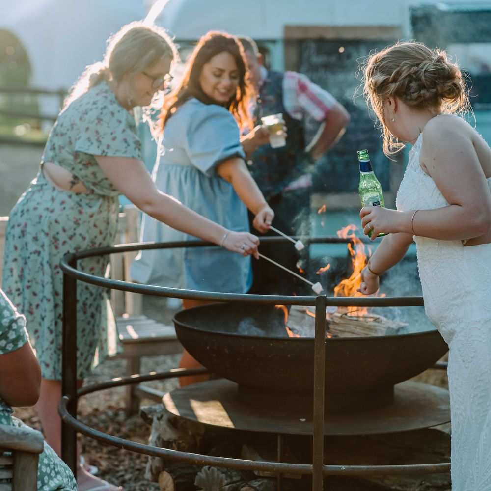 Paella is cooked in large skillet outdoors whilst guests watch 