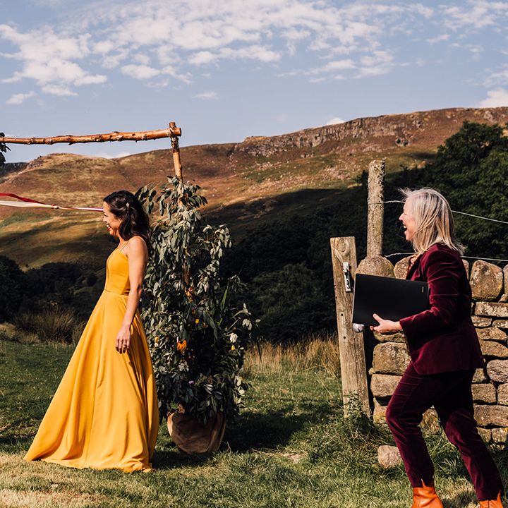 Bride & groom stand in front of rolling hills outdoors