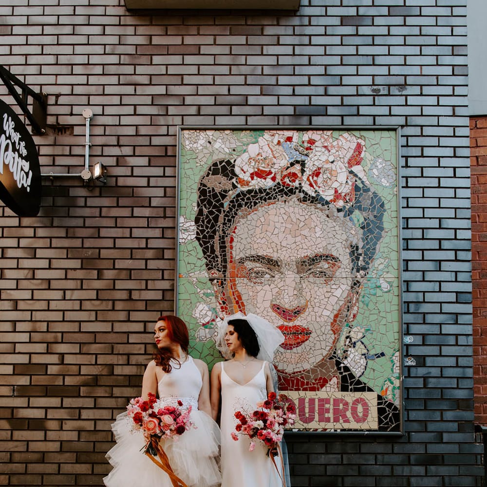 Manchester elopement with two brides in a high low layered tulle skirt wedding dress and a satin slip wedding dress with long bow veil 