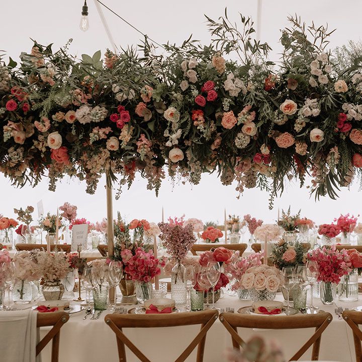 Extravagant pink, coral and white wedding flower display with roses, carnations and many more  