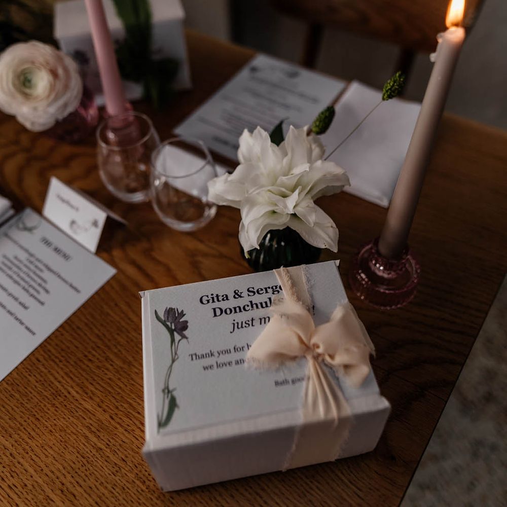 long coloured taper candles and wedding favour boxes on the wedding reception tables 