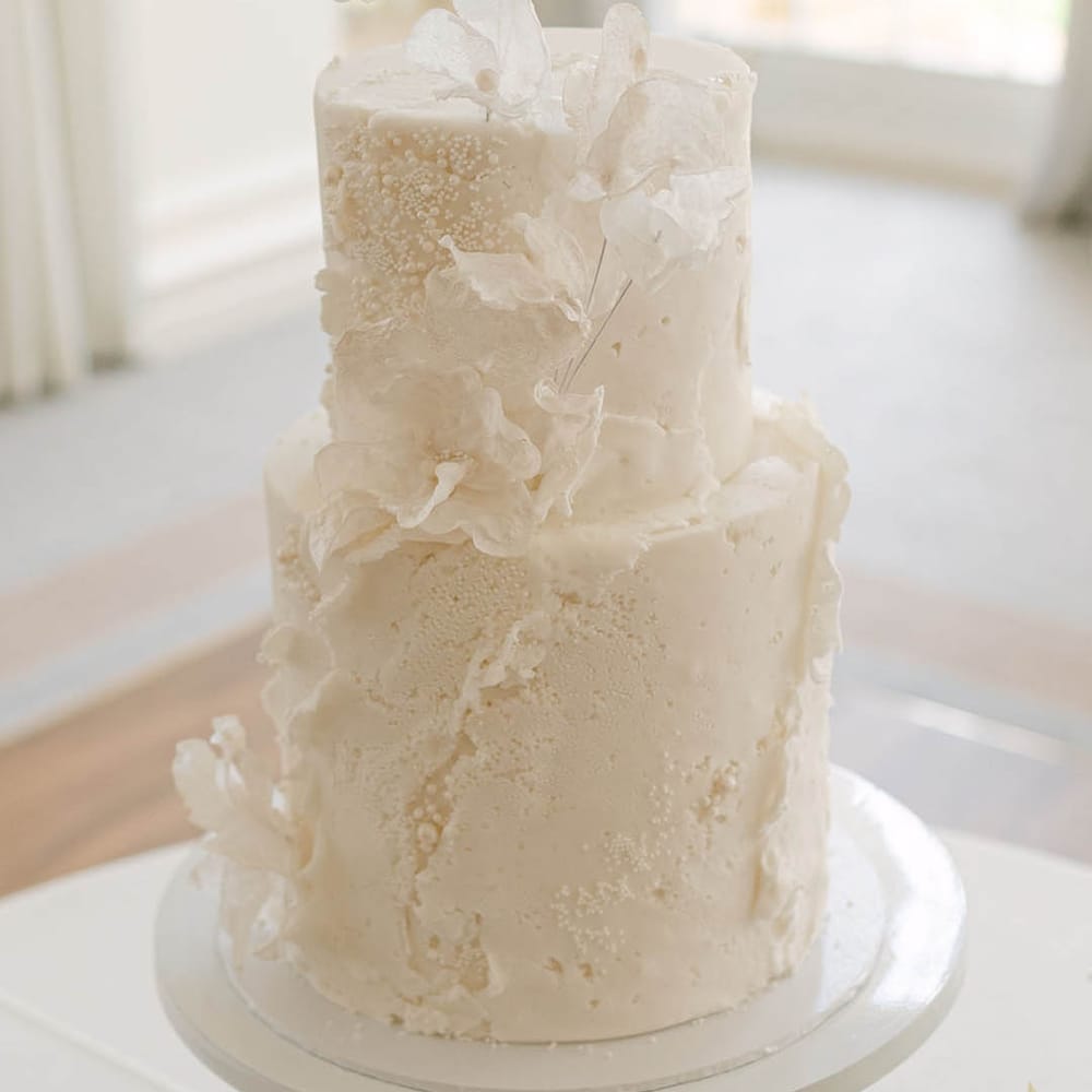 Modern and classic two tier white iced wedding cake with attention to texture 