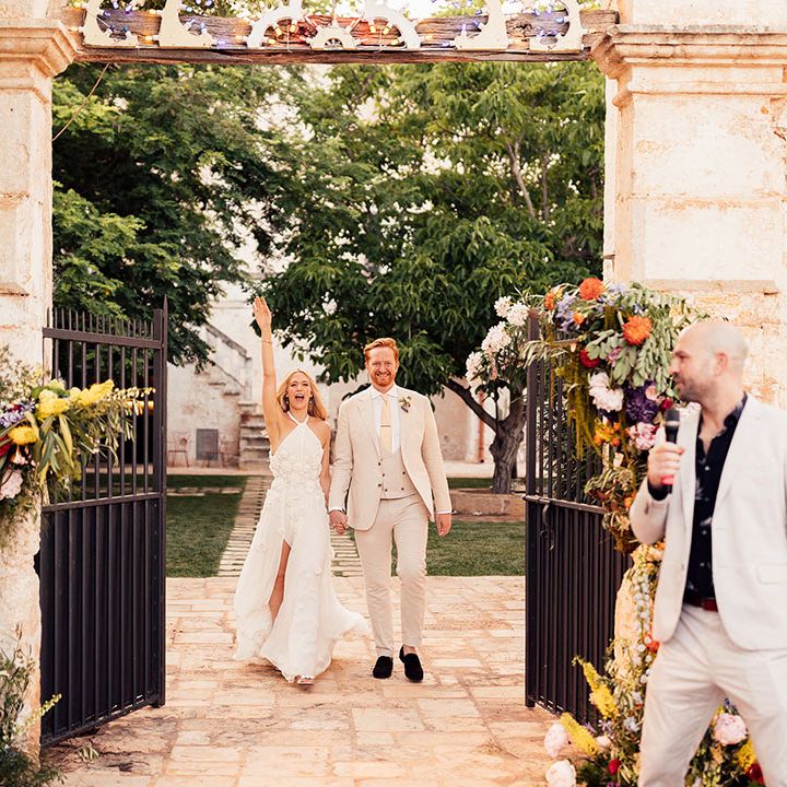 Bright and colourful flower columns decorate the entrance to the outdoor wedding reception 