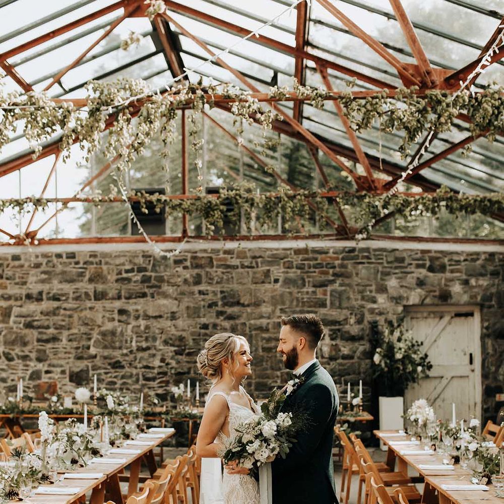 Bride in sleeveless lace detail wedding dress and groom in dark suit embracing at Plas Dinam country house