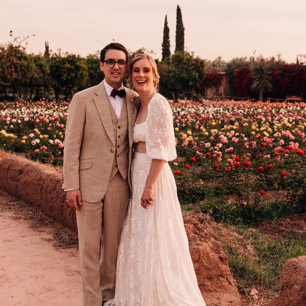 Golden hour wedding portrait of the bride and the groom next to fields of colourful flowers 