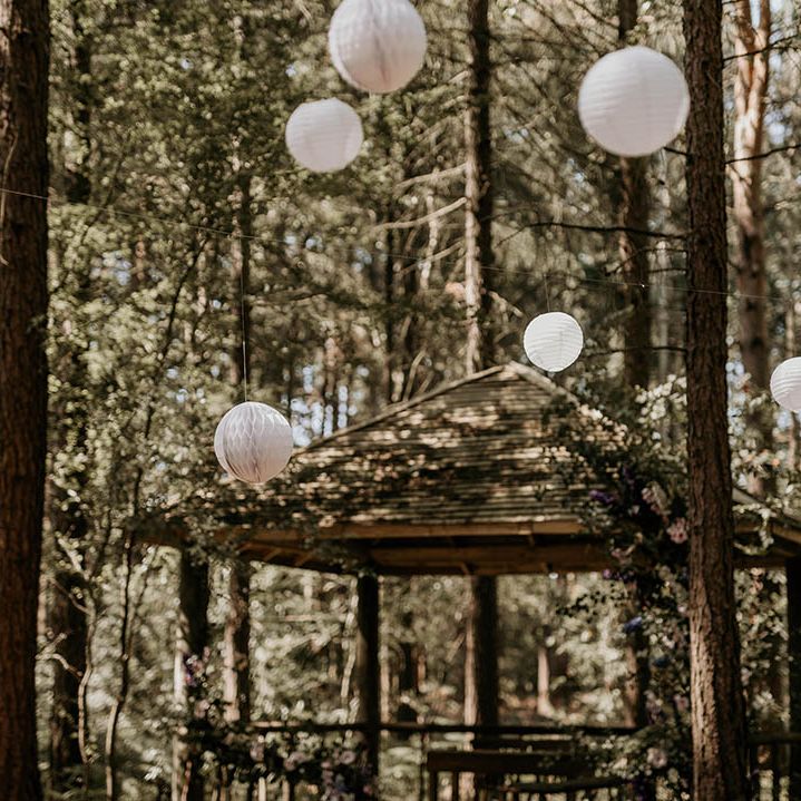 Camp Katur wedding in a woodland with white paper lanterns and gazebo