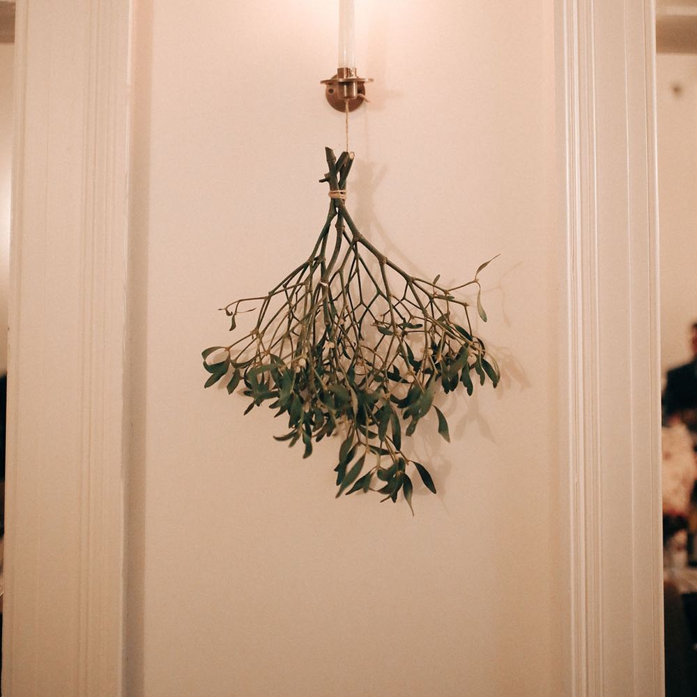 Festive seasonal winter wedding decorations under sconces 