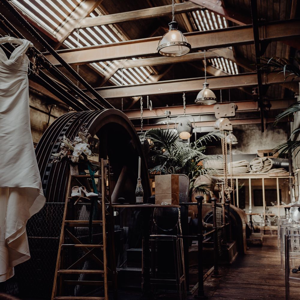 Enzoani off the shoulder wedding dress hanging up at Holmes Mill 