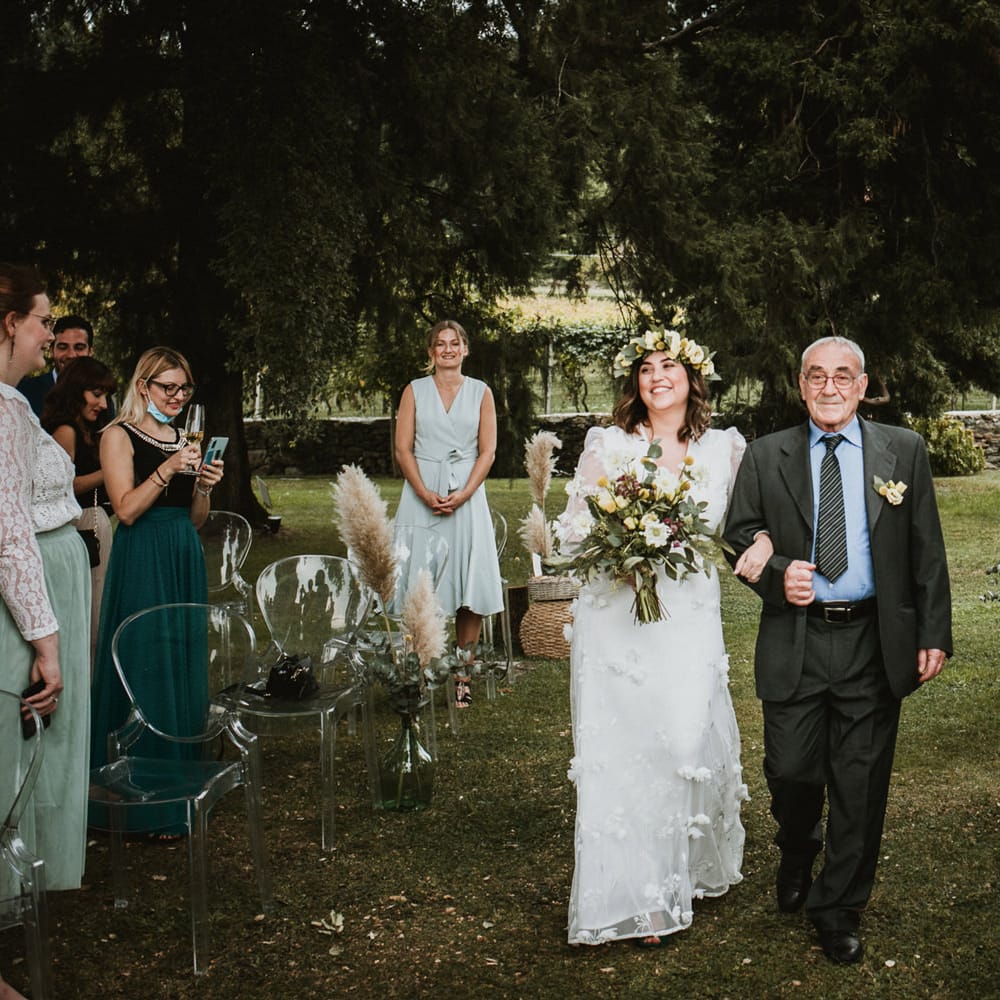 Outdoor wedding ceremony bridal entrance in a white wedding dress with flowers and flower crown 