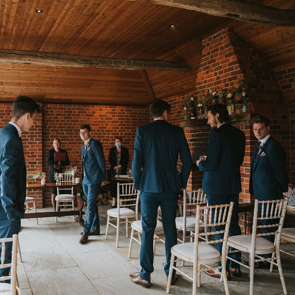 Groom waits for bride at the end of aisle during wedding ceremony