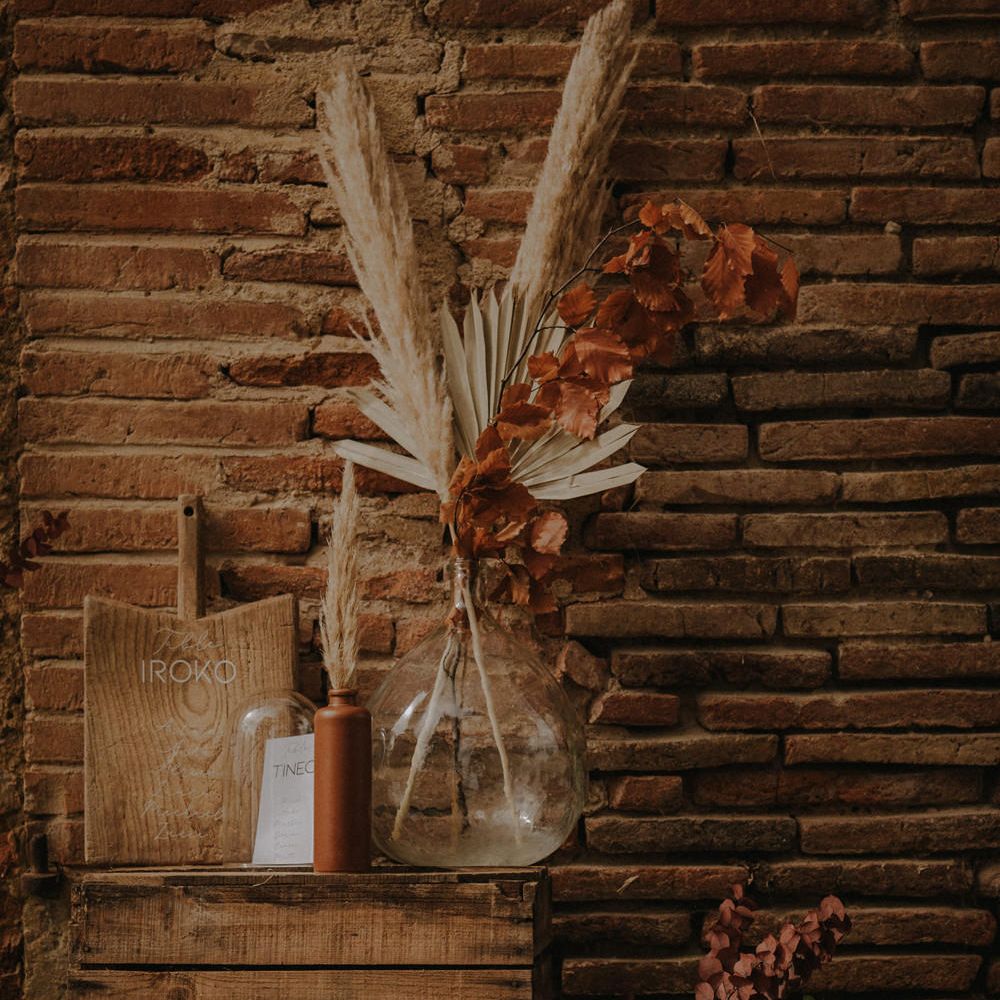 Table plan with apothecary jar filled with dried grasses and a wooden chopping board with white marker pen