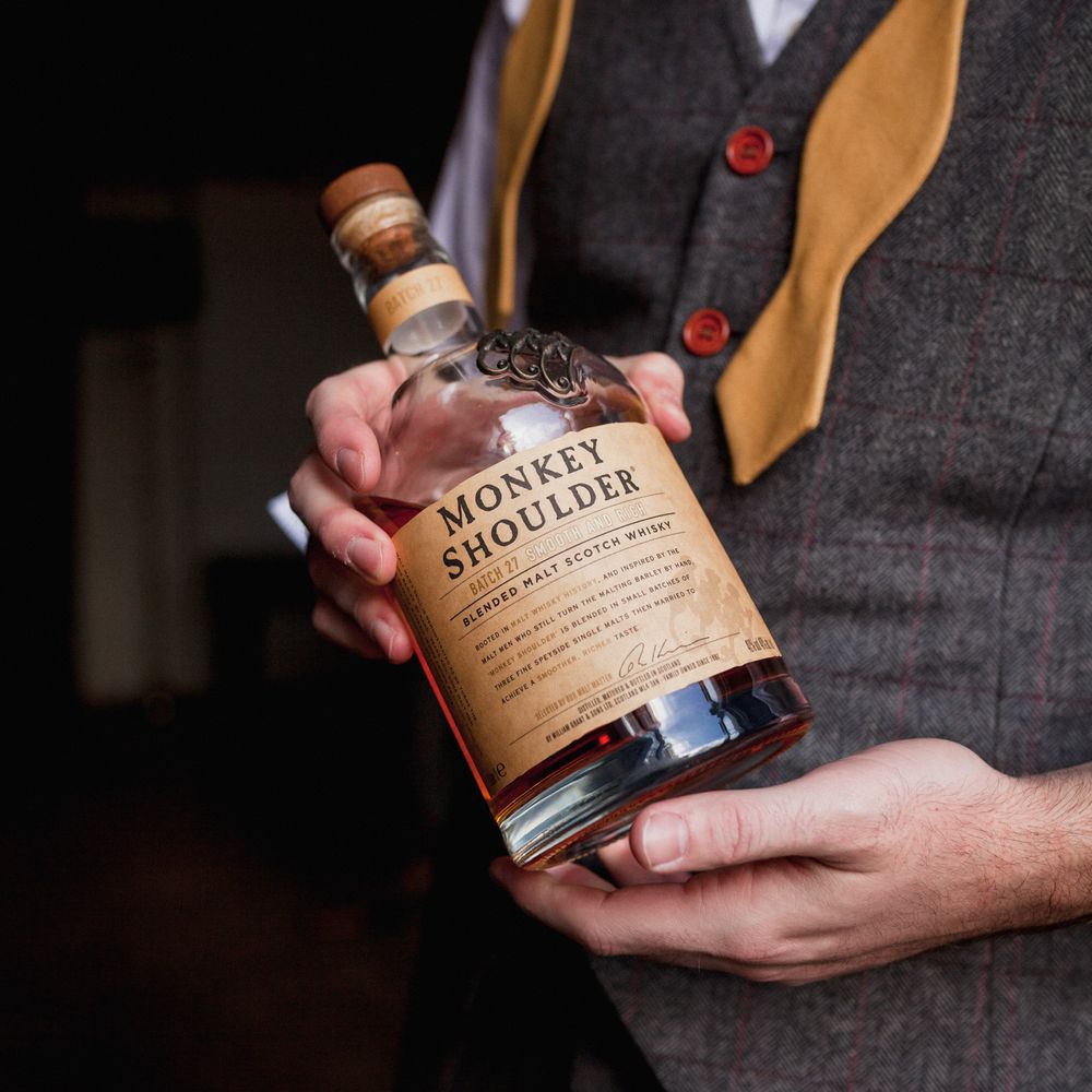 Groom holding monkey shoulder scotch whisky 