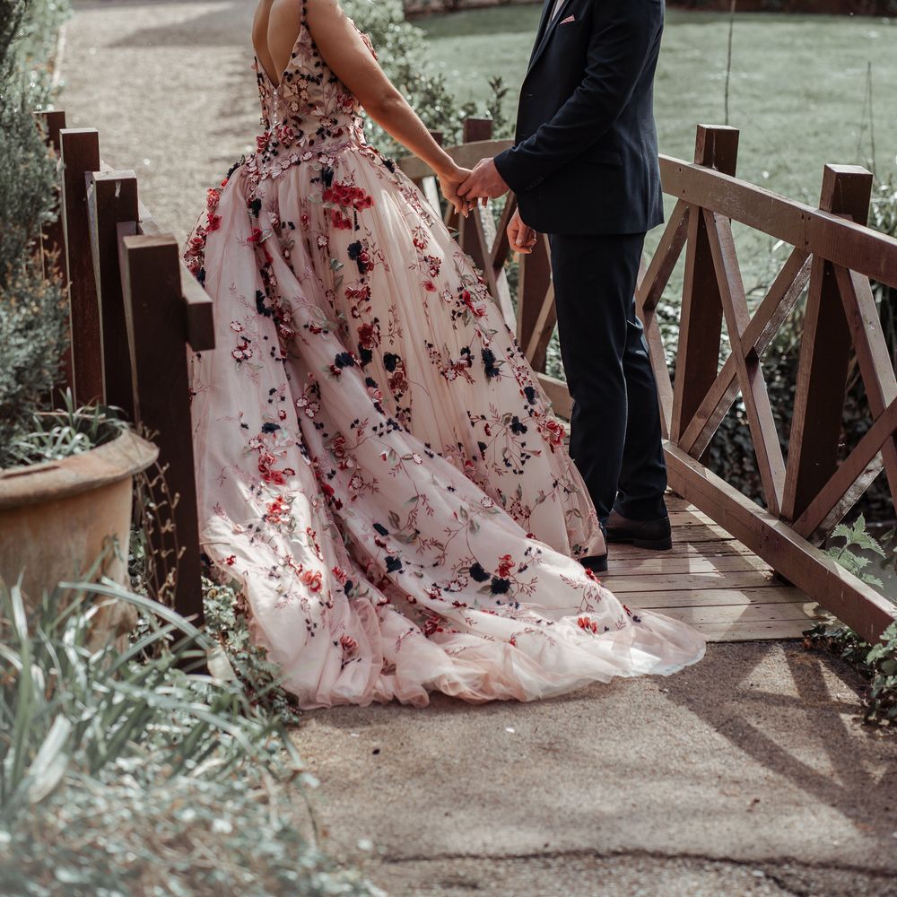 Bride & groom stand on wooden bridge during on their wedding day