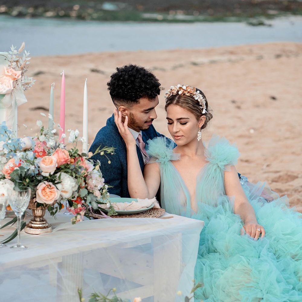 Intimate bride and groom portrait on the beach with bride in a coloured tulle wedding dress and metal headband 