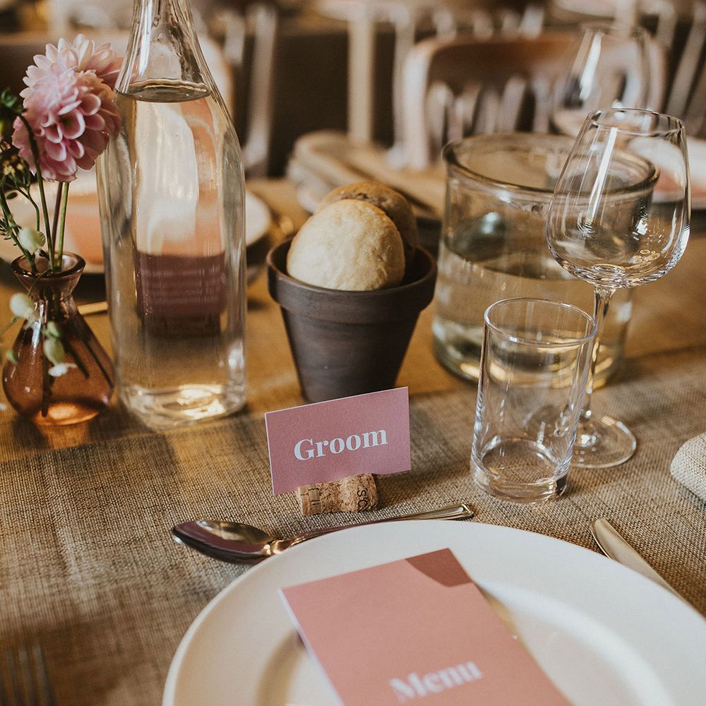 Wedding tablescape complete with pale pink stationery on wooden table