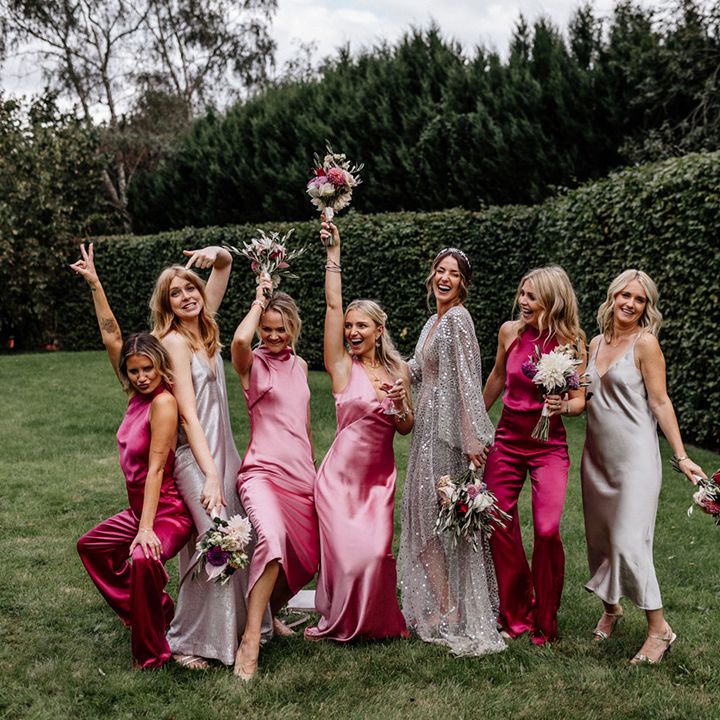 Bridal party portrait with bride in a silver sequin wedding dress with her bridesmaids in satin dresses and jumpsuits 