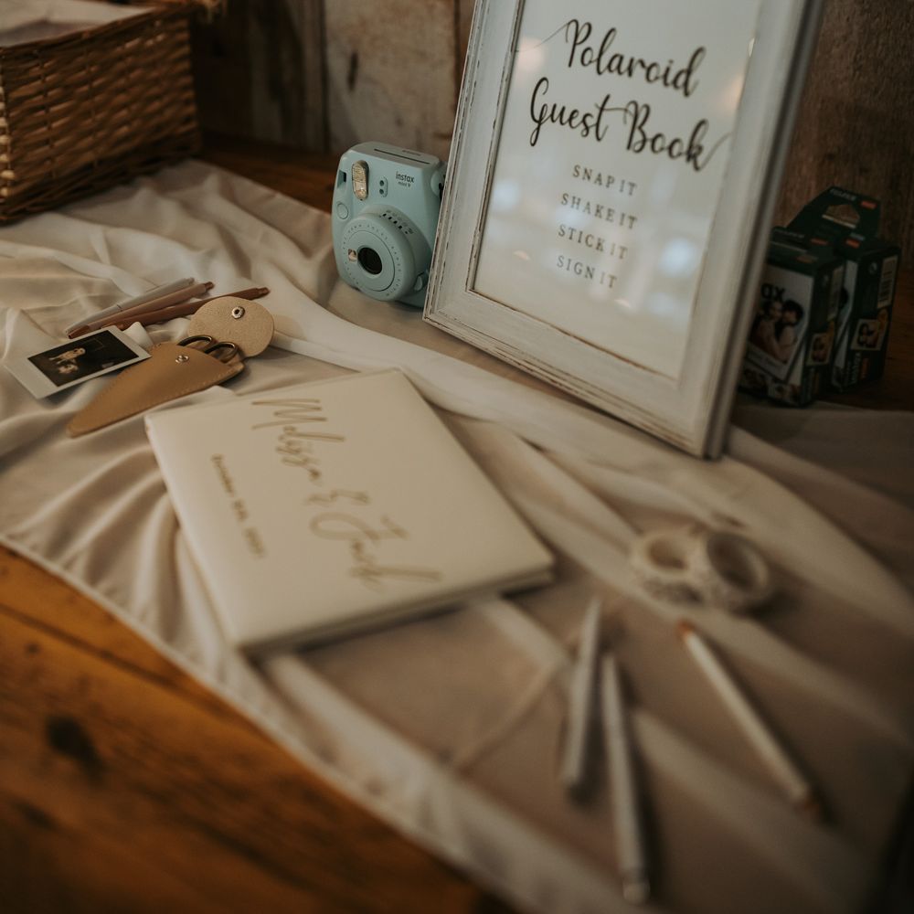 Polaroid guest book wedding sign with blue polaroid and white guestbook