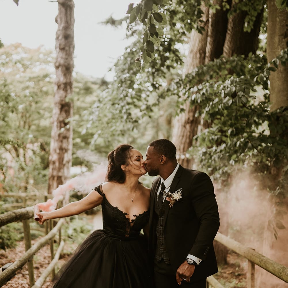 Bride & groom kiss one another outdoors after their wedding ceremony